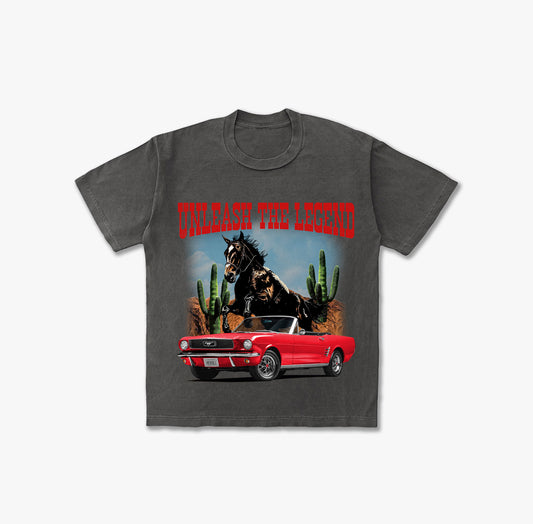 Washed grey t-shirt featuring a red vintage Ford Mustang convertible, a wild black horse rearing, desert landscape with cacti, and red text 'UNLEASH THE LEGEND'.