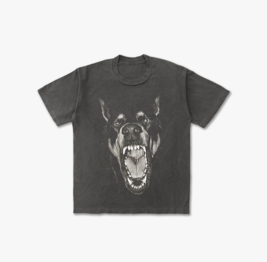 T-shirt featuring a large, high-contrast graphic print of a Doberman Pinscher's head with its mouth wide open, snarling and showing teeth, in a black and white or grayscale effect.